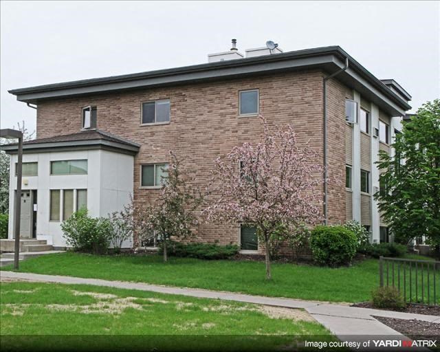 a brick building with a flowering tree in front of it