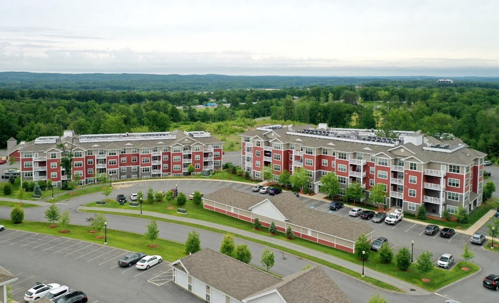 an aerial view of an apartment building and parking lot