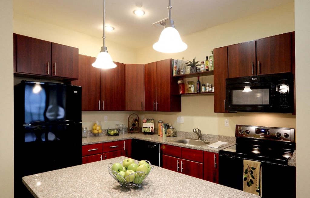 a kitchen with black appliances and a granite counter top
