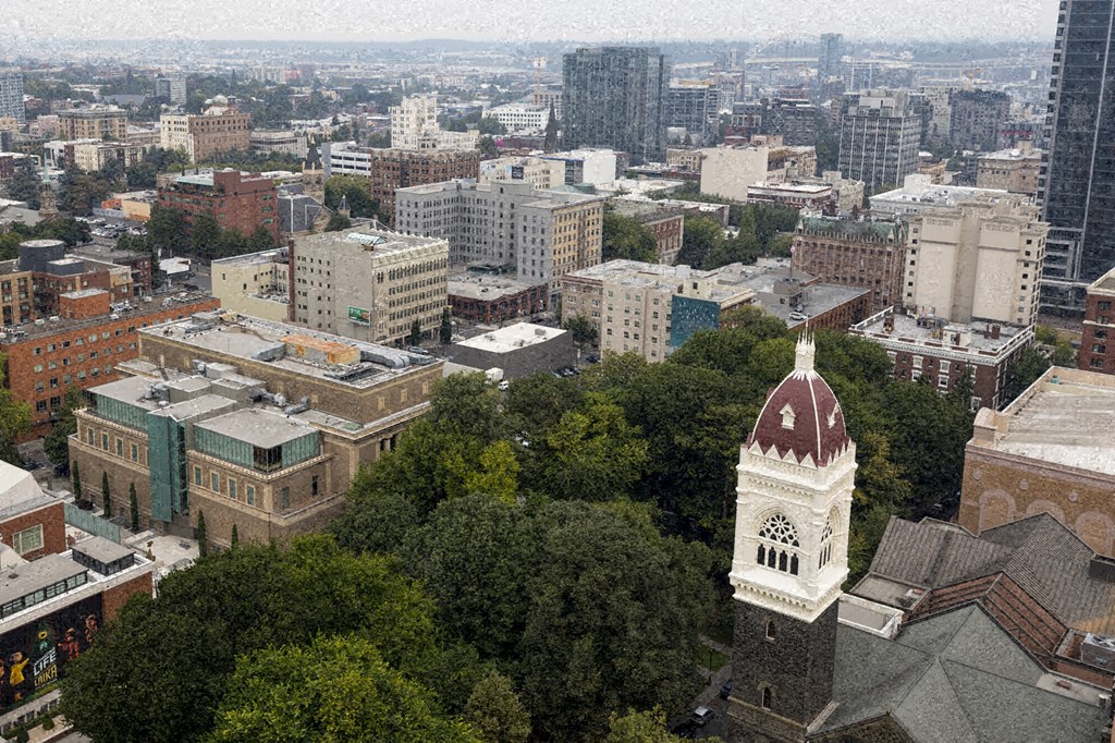 an aerial view of a city with a church tower