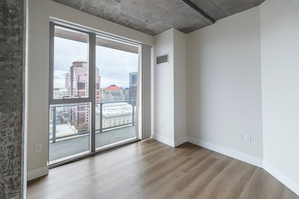 a living room with a large window and a wooden floor