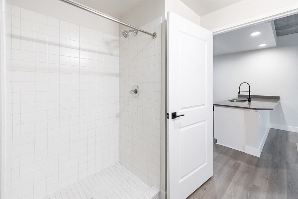a white bathroom with a shower and a sink