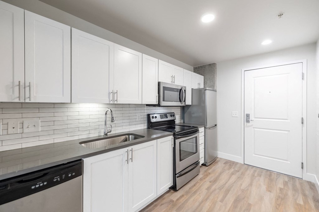 a kitchen with white cabinets and stainless steel appliances