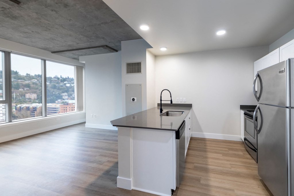 a kitchen with an island and stainless steel appliances and a large window
