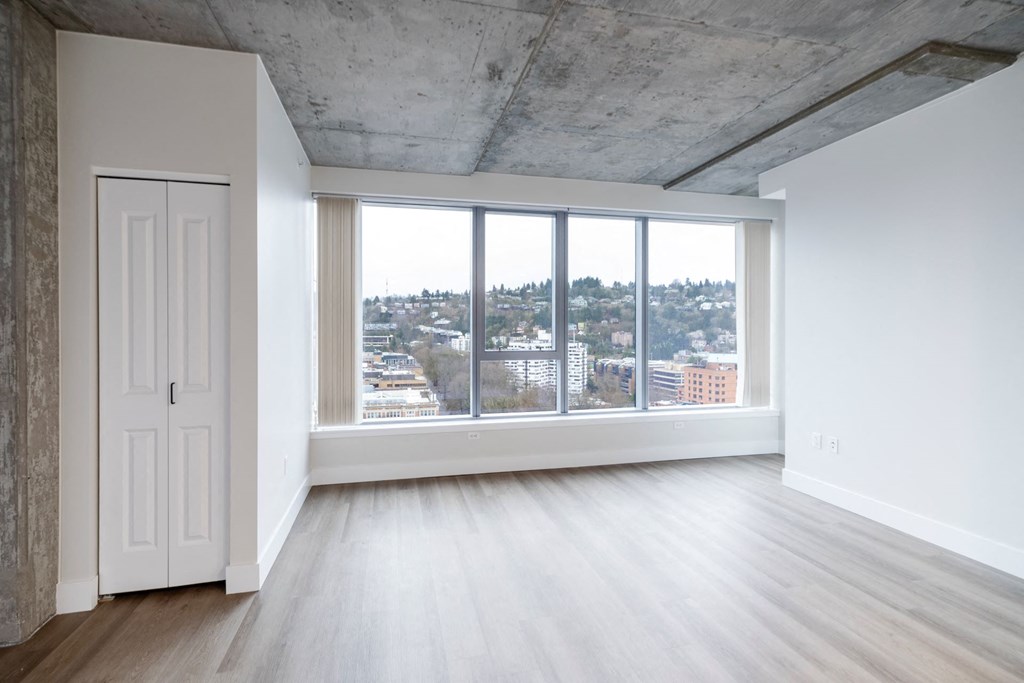an empty living room with a large window and a door