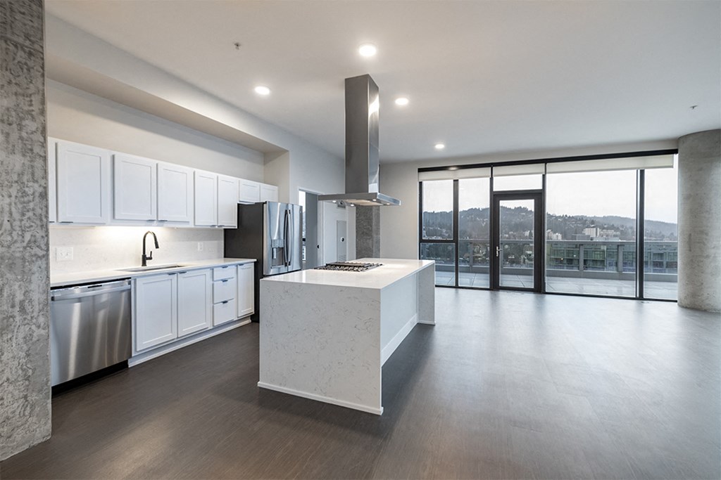 a large white kitchen with a large island and a balcony