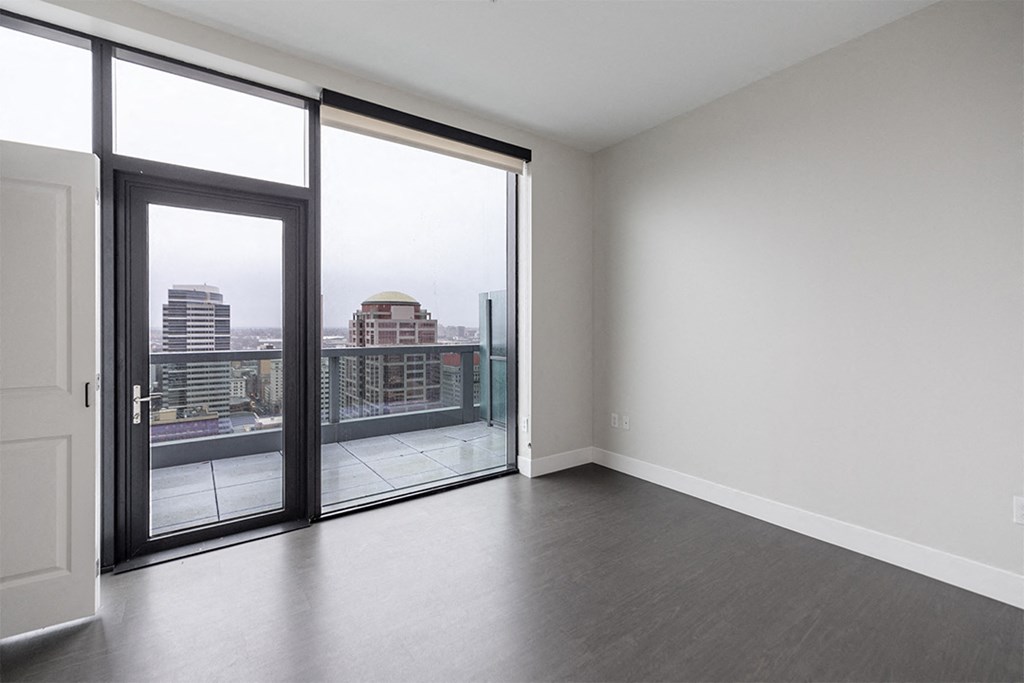 an empty living room with sliding glass doors and a city view