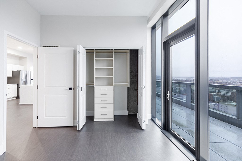 a living room with a closet and a large window