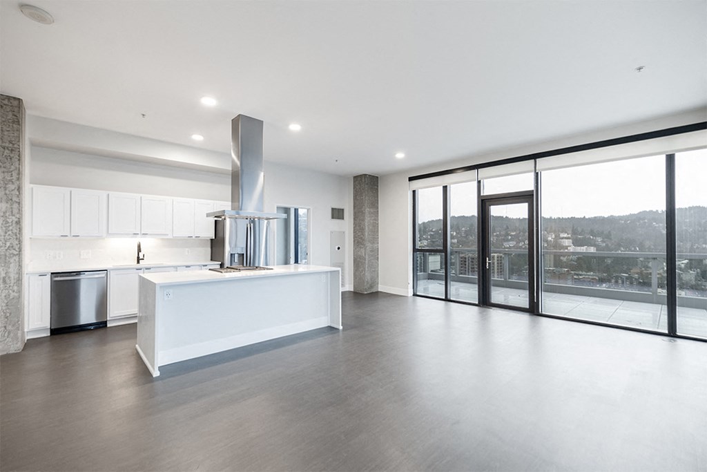a white kitchen with a large island and a large window
