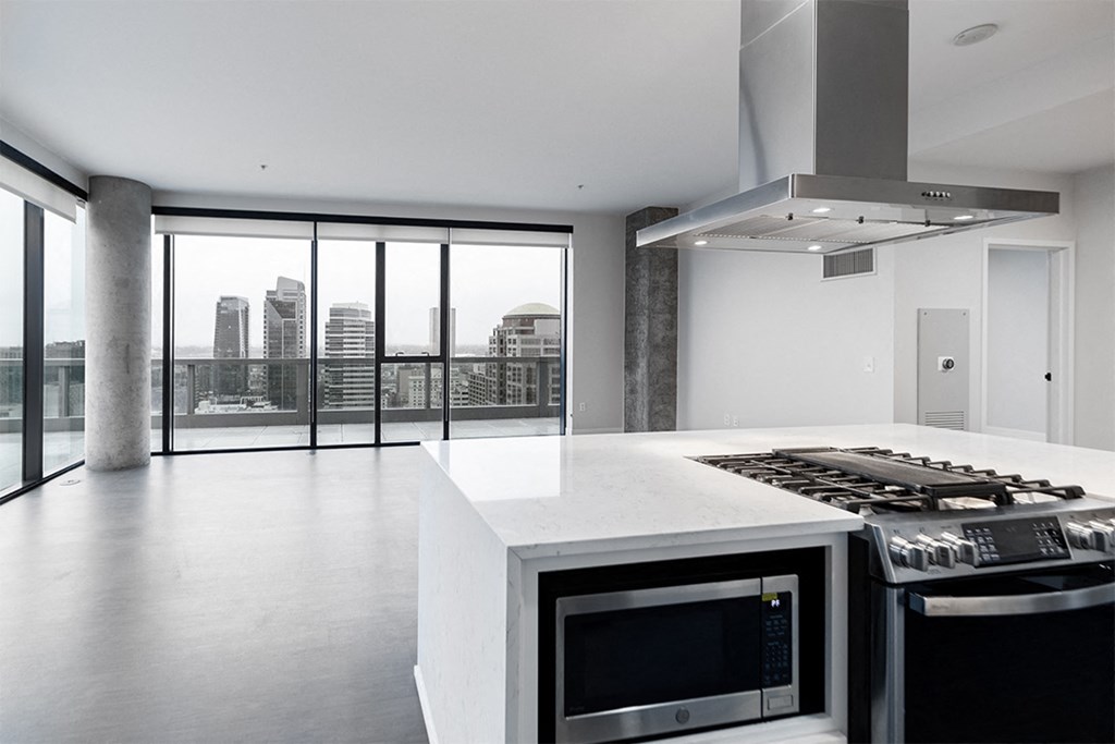 a large white kitchen with a stove and a large window