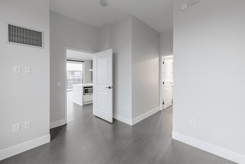 an empty living room with white walls and wood floors