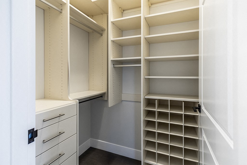 a walk in closet with shelves and drawers