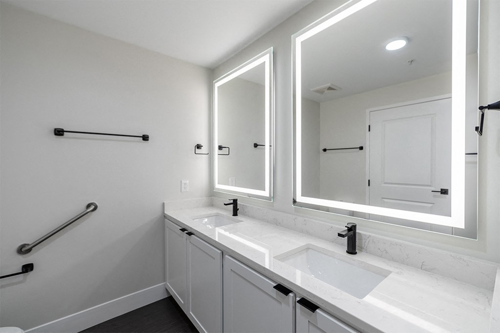 a bathroom with two sinks and two mirrors