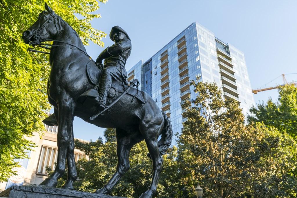 a statue of a man on a horse in front of a building