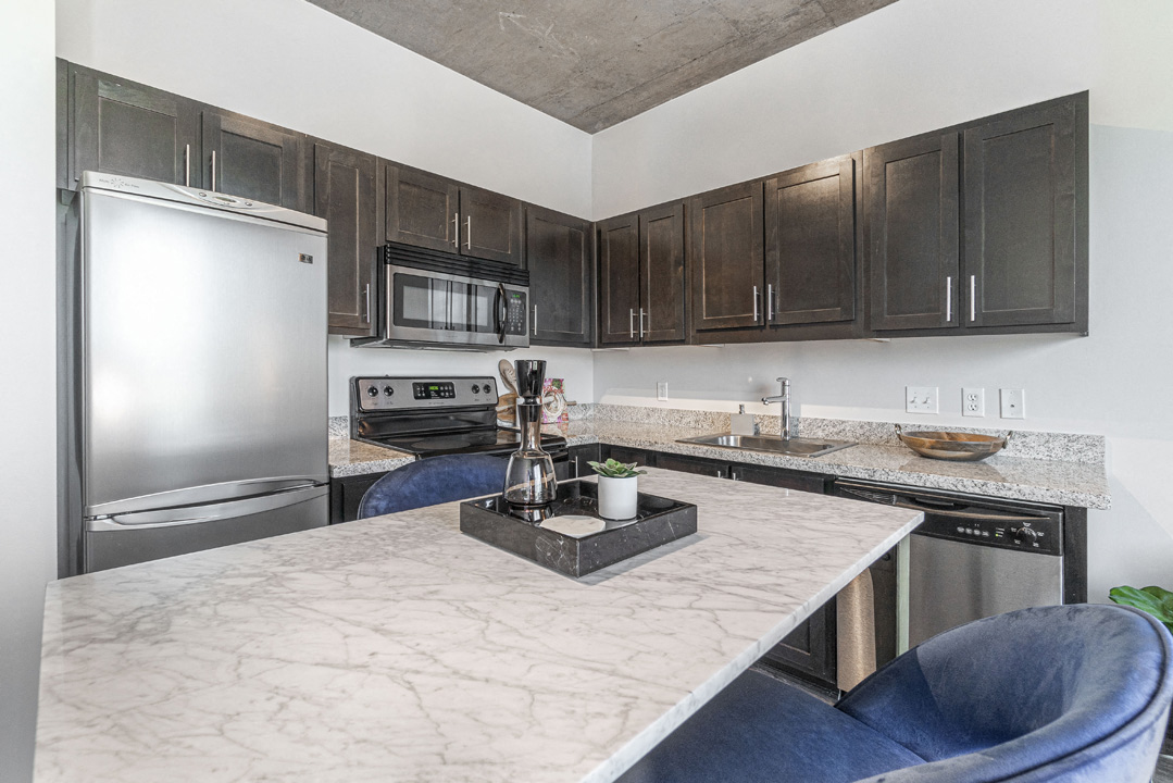 a kitchen with stainless steel appliances and marble counter tops