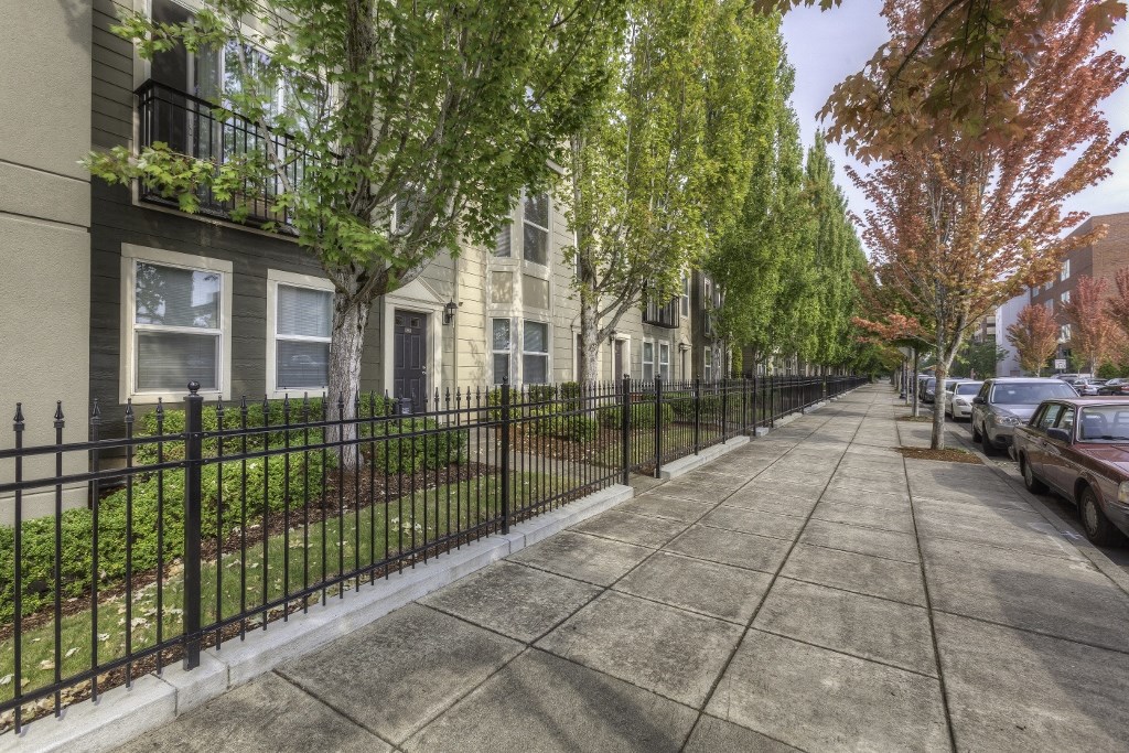 a sidewalk in front of a row of apartment buildings