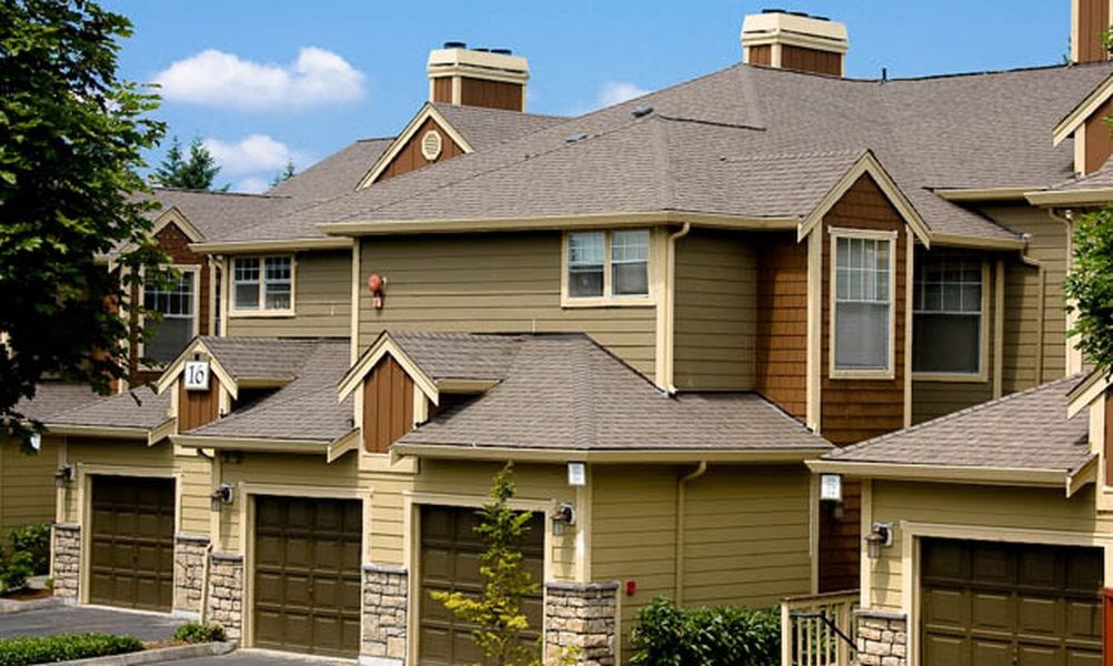 a yellow house with a roof and garages