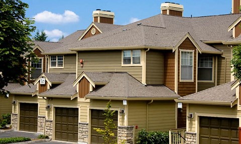 a yellow house with a roof and garages