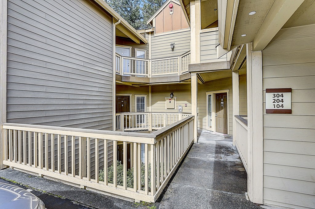 the pathway to the entrance of an apartment building with a porch