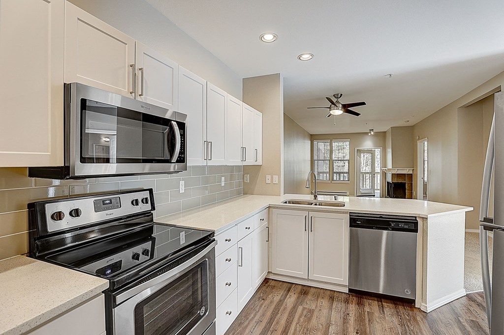 an updated kitchen with stainless steel appliances and white cabinets