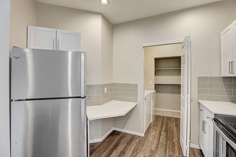 a kitchen with stainless steel refrigerator and white cabinets