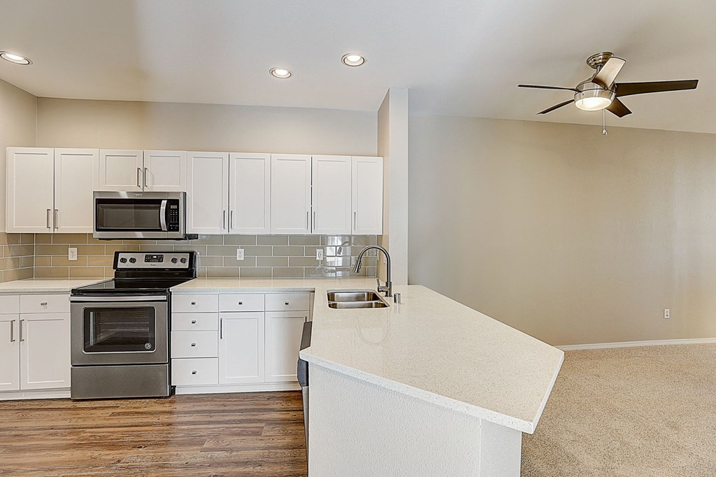 a renovated kitchen with white cabinets and stainless steel appliances