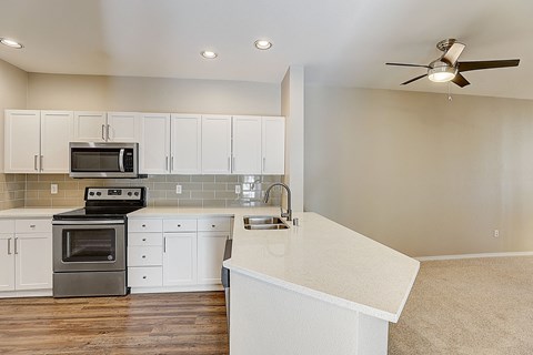a renovated kitchen with white cabinets and stainless steel appliances