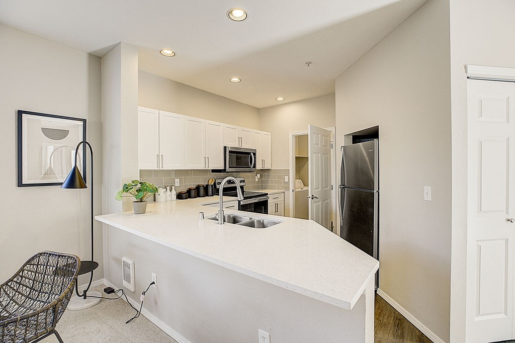 a kitchen with an island and a stainless steel refrigerator
