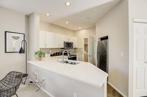 a kitchen with an island and a stainless steel refrigerator