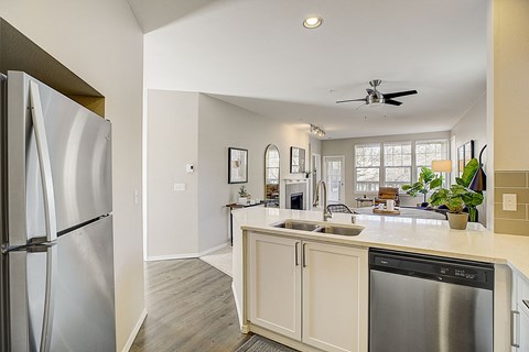 a kitchen and living room with a refrigerator and a sink