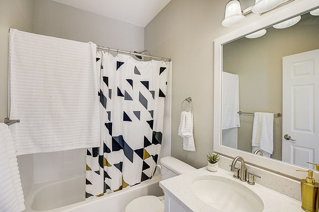 a white bathroom with a black and white shower curtain