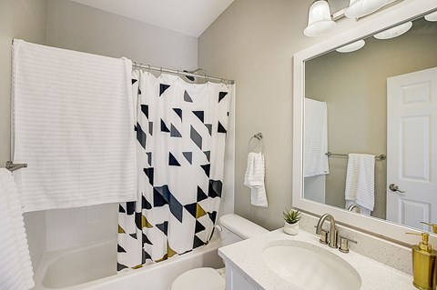 a white bathroom with a black and white shower curtain
