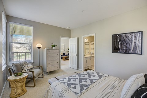 a bedroom with a bed and a chair and a closet