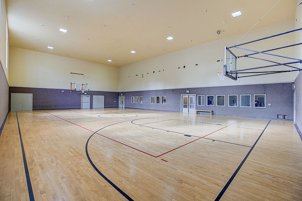 the multipurpose gym has a wood floor and a basketball court