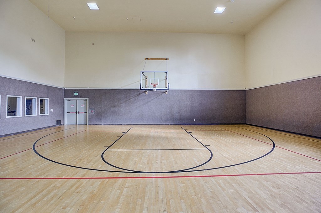 a basketball court in an empty gym with a basketball hoop
