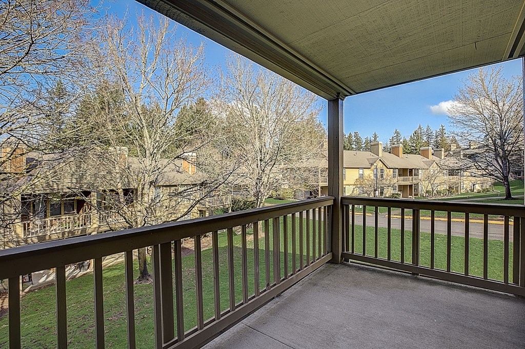 a balcony with a view of a yard and trees