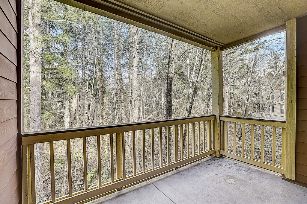 a balcony with a view of the trees