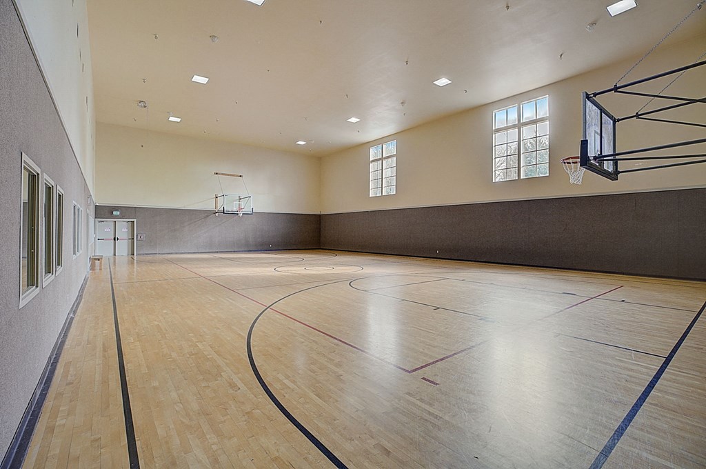 a basketball court in an empty gym with wood floors