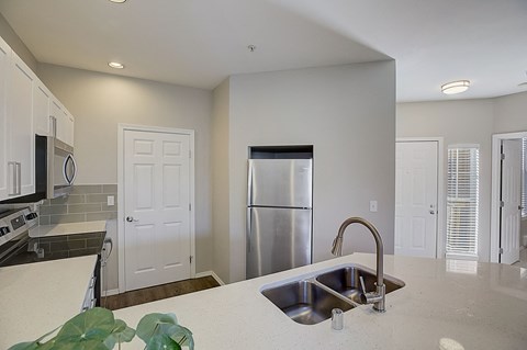 a kitchen with a sink and a stainless steel refrigerator
