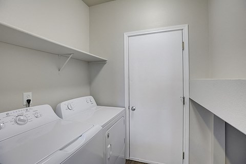 an empty laundry room with two washer and dryers
