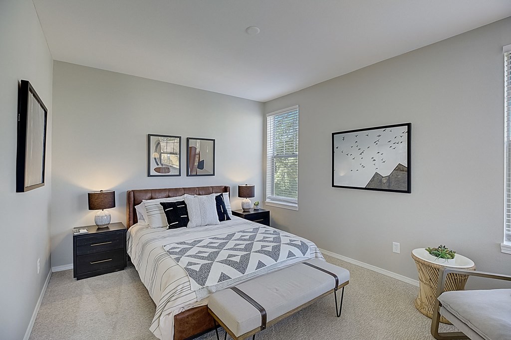 a bedroom with a bed and a chair and a window