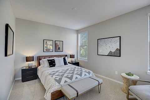 a bedroom with a bed and a chair and a window