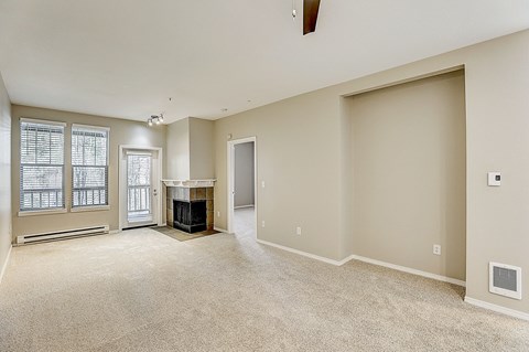 an empty living room with a fireplace and a doorway