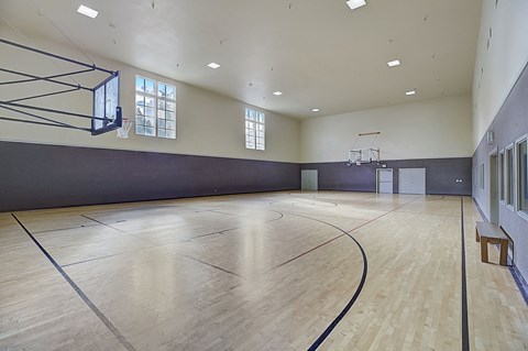 the multipurpose gym has a wood floor and a basketball court