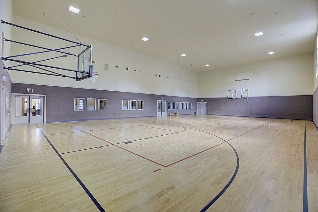 a basketball court in the center of a large room with wood floors