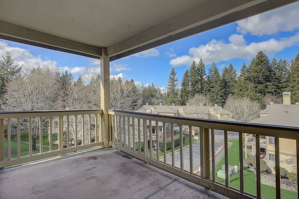a balcony with a view of a yard and trees