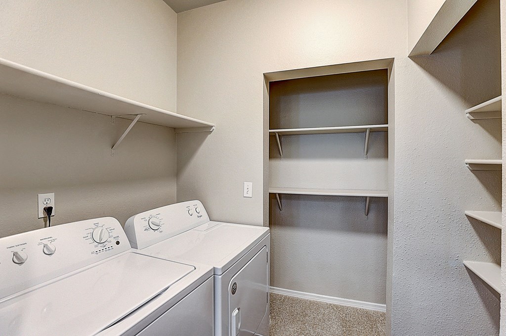 an empty laundry room with a washer and dryer