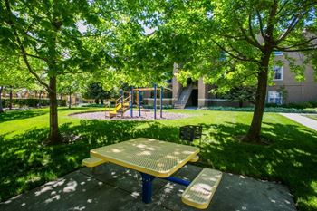 Children's Playground with Shaded Grass Area at Apartments for Rent 94534