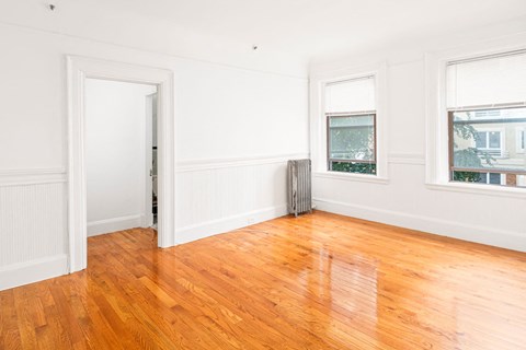 a living room with a hard wood floor and white walls