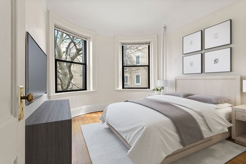 a bedroom with a bed and two windows